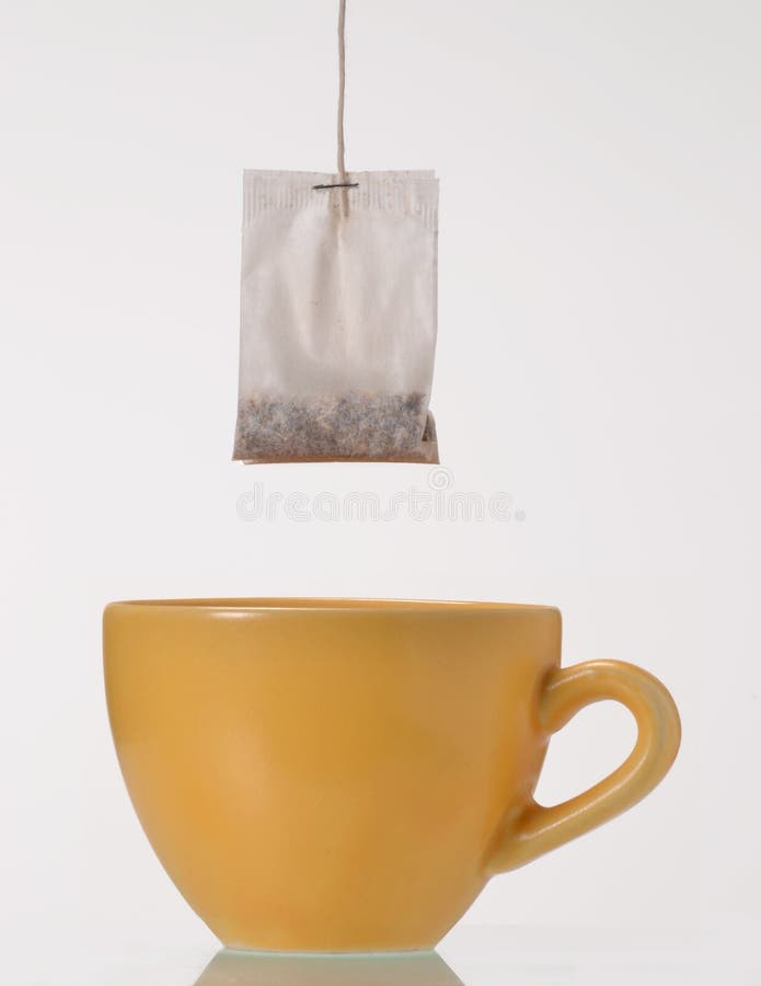 Soaking a tea bag on a yellow cup,Tea bag on cup. Soaking a tea bag on a yellow cup,Tea bag on cup.