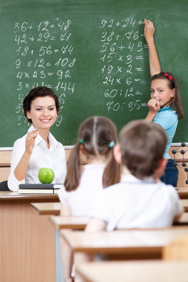 Teacher asks pupils at the chalkboard royalty free stock photo