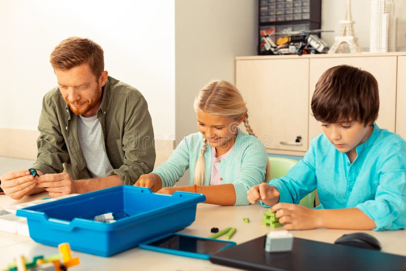 Teacher building different figures with his pupils. stock photography