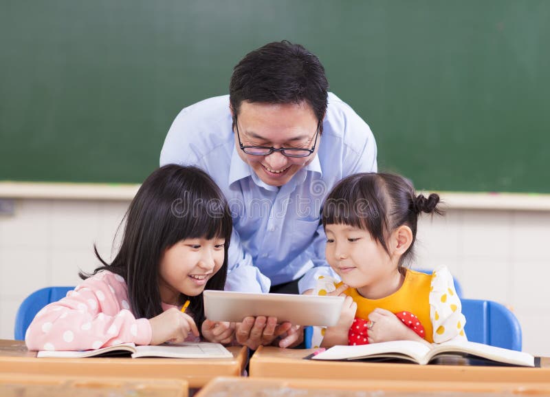 Teacher and children with digital tablet or ipad royalty free stock photo