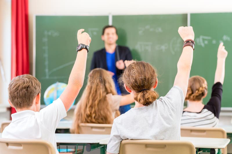 Teacher educate or teaching a class of pupils in school royalty free stock photo