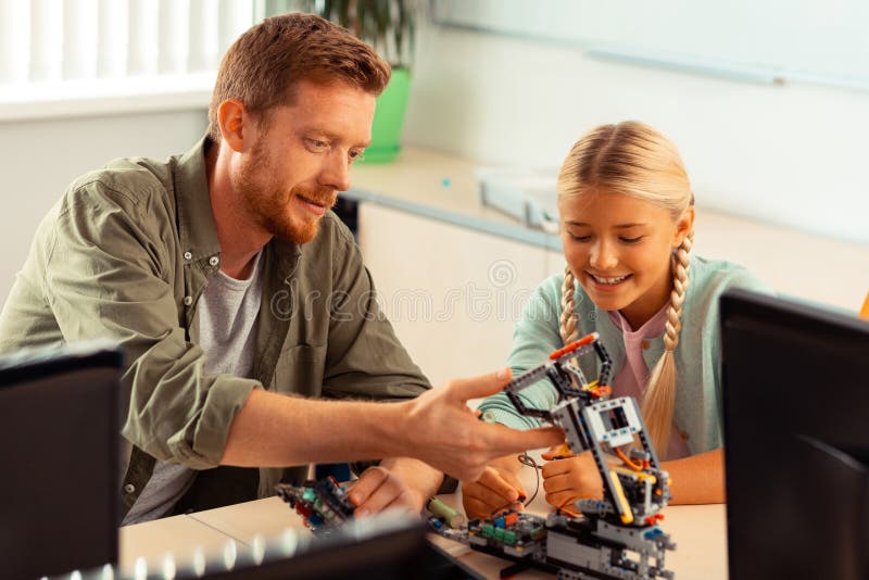 Teacher evaluating the robot made by the schoolgirl. royalty free stock photography
