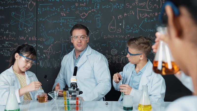 Teacher explain about chemical theory while student mix solution. Edification stock video