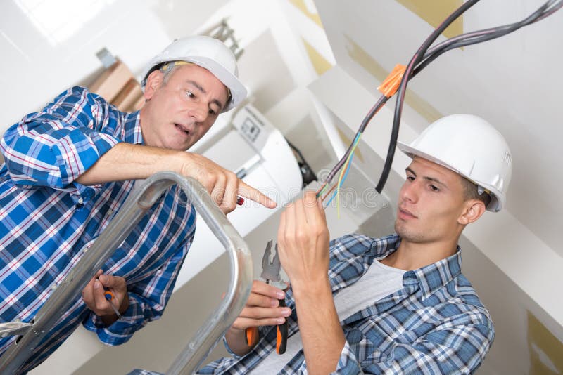 Teacher guiding electrical apprentice stock photography Teacher guiding electrical apprentice stock photography