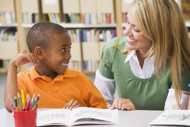 Insegnante di scuola dell'infanzia di aiutare gli studenti con capacità di lettura.