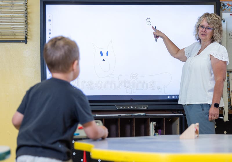 A teacher is pointing to the letter S on the computer screen royalty free stock image