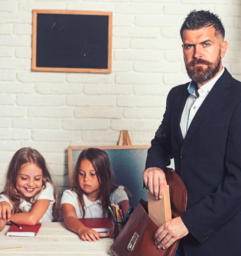 Teacher put book to a briefcase at class with kids. royalty free stock photos Teacher put book to a briefcase at class with kids. royalty free stock photos