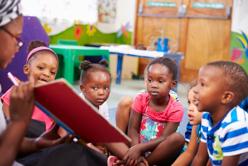 Teacher reading a book with a class of preschool children royalty free stock image Teacher reading a book with a class of preschool children royalty free stock image