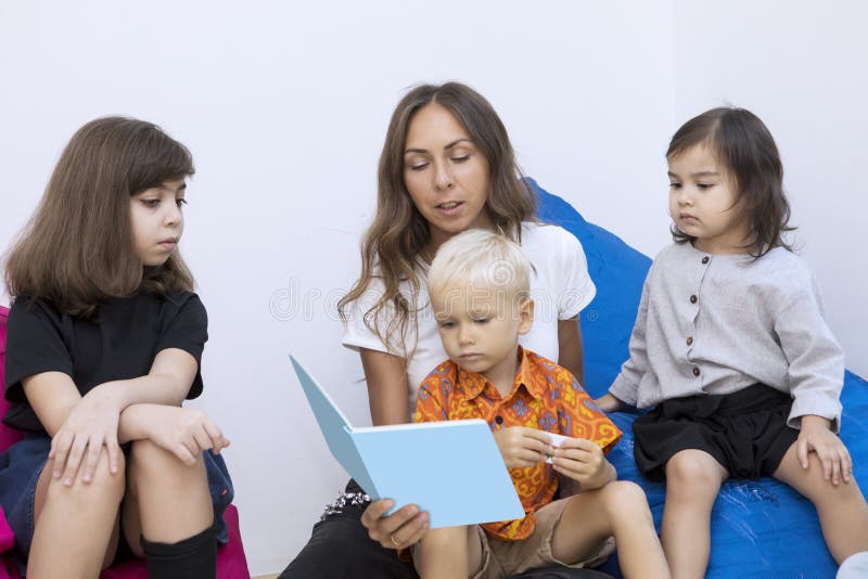 Teacher reading a storybook to a group of kids royalty free stock photography Teacher reading a storybook to a group of kids royalty free stock photography