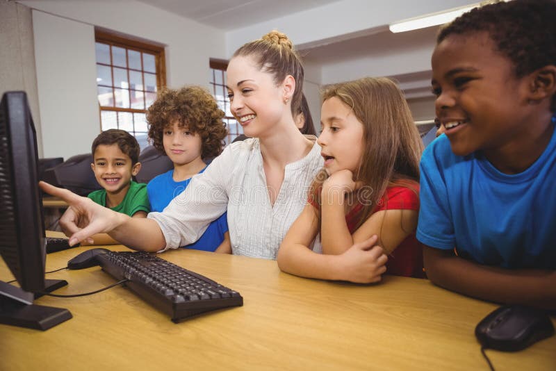 Teacher showing students how to use a computer at the elementary school