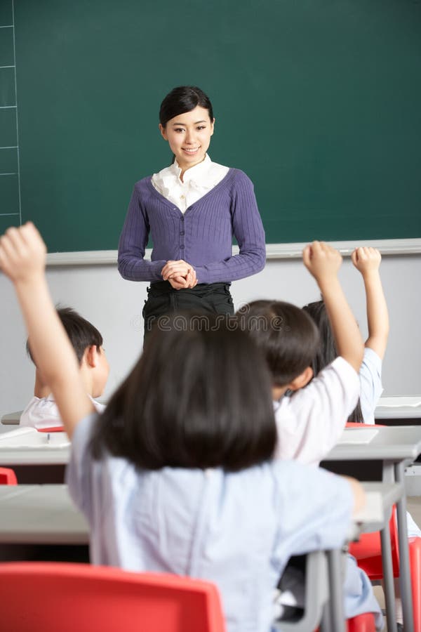Teacher With Students In Chinese School Classroom Smiling. Smiling asking stock images, royalty-free photos and pictures