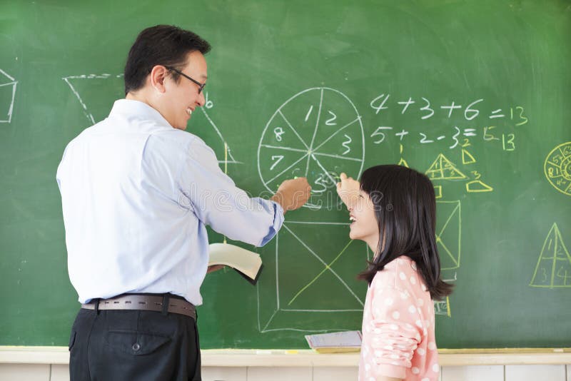 Teacher teach student to solve the math questions stock photography