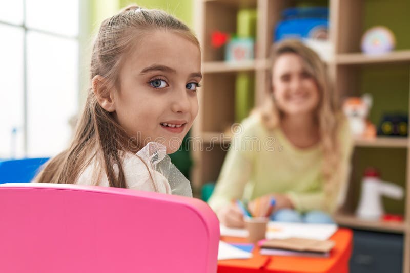 Teacher and Toddler Sitting on Table Drawing on Paper at Kindergarten
