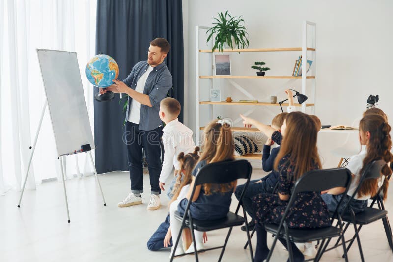 Teaching Geography Lesson by Using Earth Globe. Group of Children