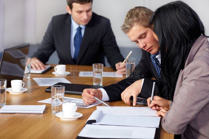 Team of 3 business people working on calculations