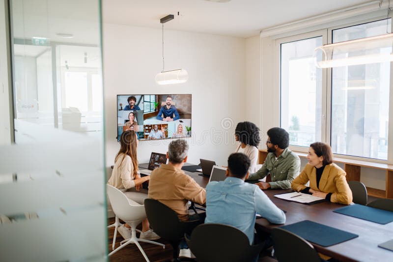 A diverse team of professionals enthusiastically participates in a video conference call royalty free stock photo
