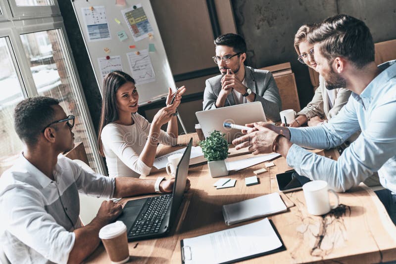 Team bei der Arbeit Draufsicht von jungen modernen Leuten in intelligentem zufälligem wir stockfoto Team bei der Arbeit Draufsicht von jungen modernen Leuten in intelligentem zufälligem wir stockfoto