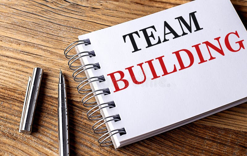 TEAM BUILDING text on notebook with pen on wooden background royalty free stock photos