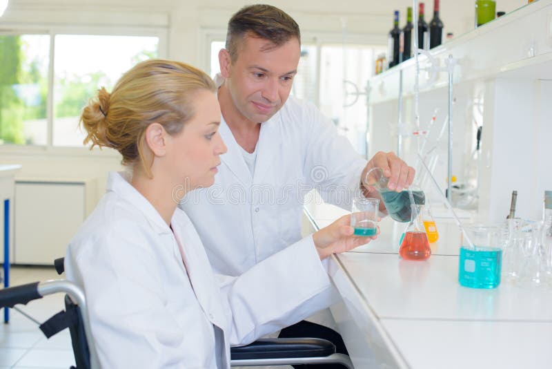 Team chemists mixing liquids royalty free stock photography