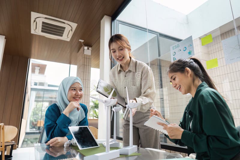 Team Collaboration and Sustainable Growth. A group discussing innovative sustainable technologies in a collaborative stock image