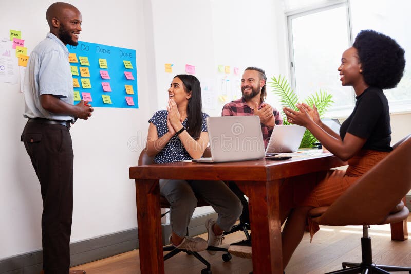Team of developers clapping hands during sprint planning meeting in boardroom. High quality photo. Boardroom table clapping stock images, royalty-free photos and pictures