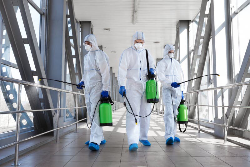 Team di virologi professionisti in tute protettive pronti per la disinfezione