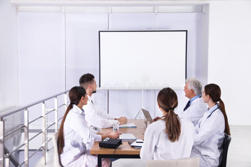 Team of doctors using video projector during conference stock photos Team of doctors using video projector during conference stock photos