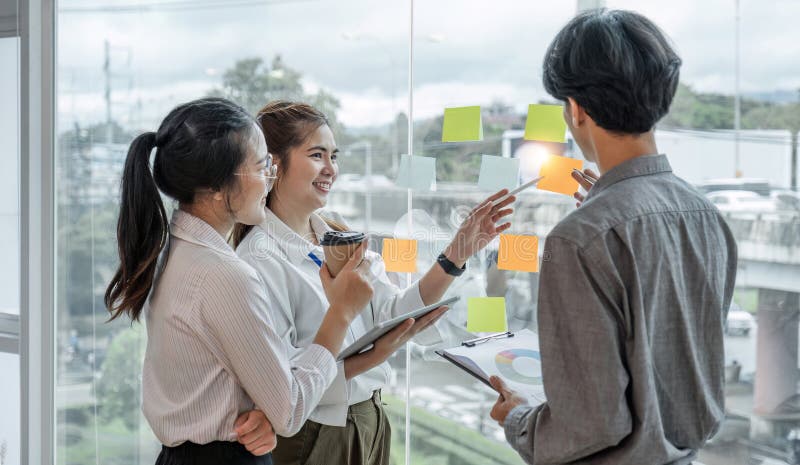 Team employees busy brainstorming develop business ideas write on colorful sticky notes, concentrated colleagues share royalty free stock photo