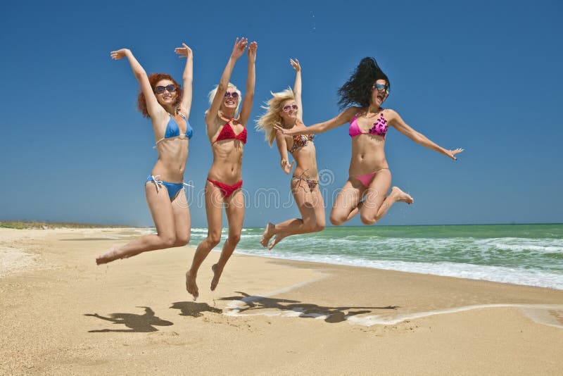 Team of friends jumping at the beach