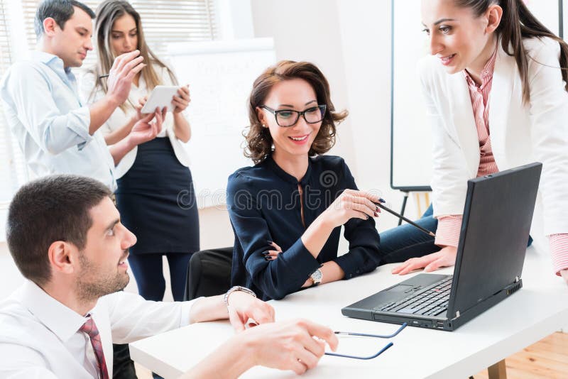 Team giving business report to boss in office