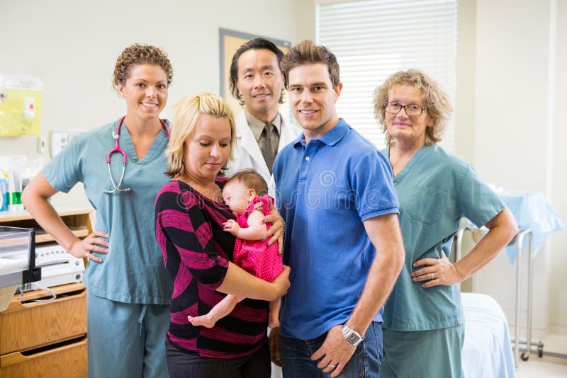 Team With Newborn Baby Girl y padres médicos adentro imagen de archivo libre de regalías Team With Newborn Baby Girl y padres médicos adentro imagen de archivo libre de regalías