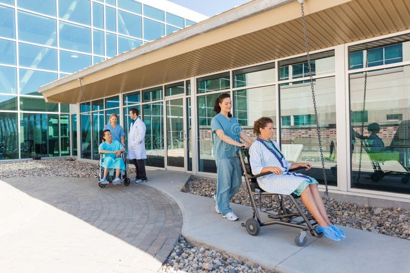 Team With Patients On Wheelchairs medico a fotografia stock Team With Patients On Wheelchairs medico a fotografia stock