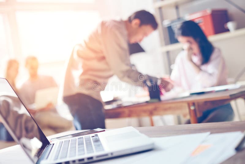 Team researching new project. Modern loft office. Open laptop on the table royalty free stock photography Team researching new project. Modern loft office. Open laptop on the table royalty free stock photography