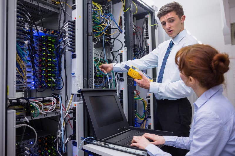 Team of Technicians Using Digital Cable Analyser on Servers Stock Image