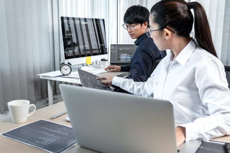 Team of two professional programmers working on website projects in software development on the desktop computer and making coding stock image