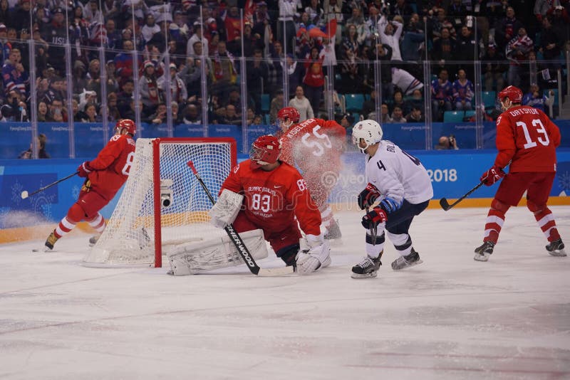 Team United States in wit in actie tegen Team Olympic Athlete van van het de Mensen` s ijshockey van Rusland het inleidende ronde royalty-vrije stock afbeelding Team United States in wit in actie tegen Team Olympic Athlete van van het de Mensen` s ijshockey van Rusland het inleidende ronde royalty-vrije stock afbeelding