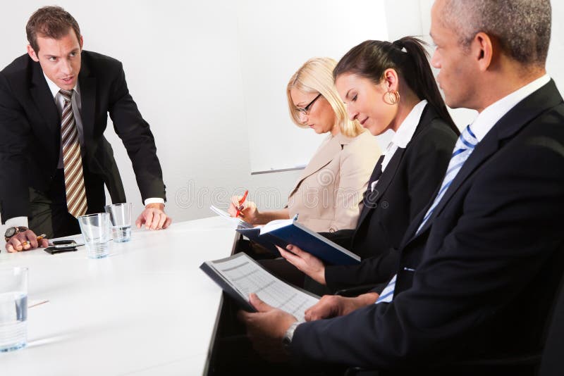 Team of business people taking notes at the meeting. Team of business people taking notes at the meeting