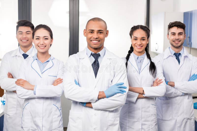 Team van jonge professionele artsen die zich in laboratorium het stellen verenigen stock afbeelding Team van jonge professionele artsen die zich in laboratorium het stellen verenigen stock afbeelding