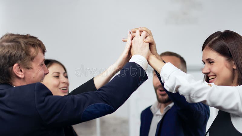 Team van zakenmensen die de winnende gebaren maken die de hand klappen en positieve emotie hebben