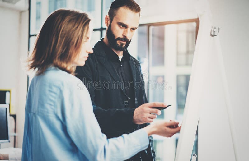 Teamwork and brainstorming concept.Young creative coworkers working with new startup project in modern office.Bearded stock images Teamwork and brainstorming concept.Young creative coworkers working with new startup project in modern office.Bearded stock images