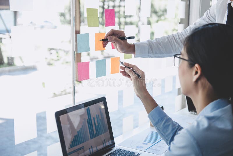 Teamwork of business team consulting market growth on financial document graph report statistics, using post it notes in glass royalty free stock images