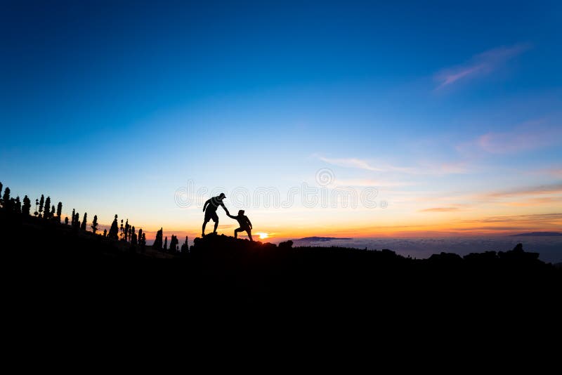 Teamwork couple climbing helping hand. Teamwork couple helping hand trust help silhouette in mountains, sunset. Team of climbers men and women hikers, help each royalty free stock photography Teamwork couple climbing helping hand. Teamwork couple helping hand trust help silhouette in mountains, sunset. Team of climbers men and women hikers, help each royalty free stock photography
