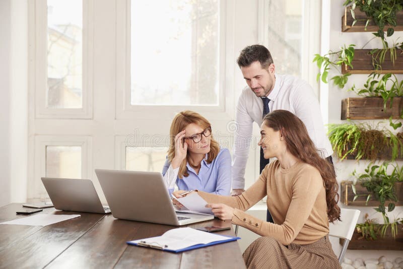 Teamwork i kontoret Grupp av aff?rsfolk som tillsammans arbetar p? b?rbara datorn i kontoret arkivbild Teamwork i kontoret Grupp av aff?rsfolk som tillsammans arbetar p? b?rbara datorn i kontoret arkivbild