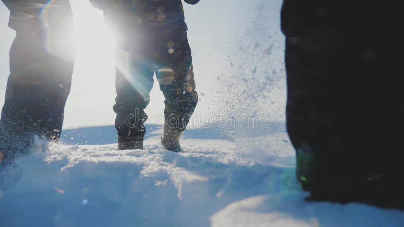 teamwork Manntouristen, die gehendes Spitzengebirgsfelsenhöchstgruppenteam-Sonnenlichtschattenbild auf Schneefuß-Winterschnee kle