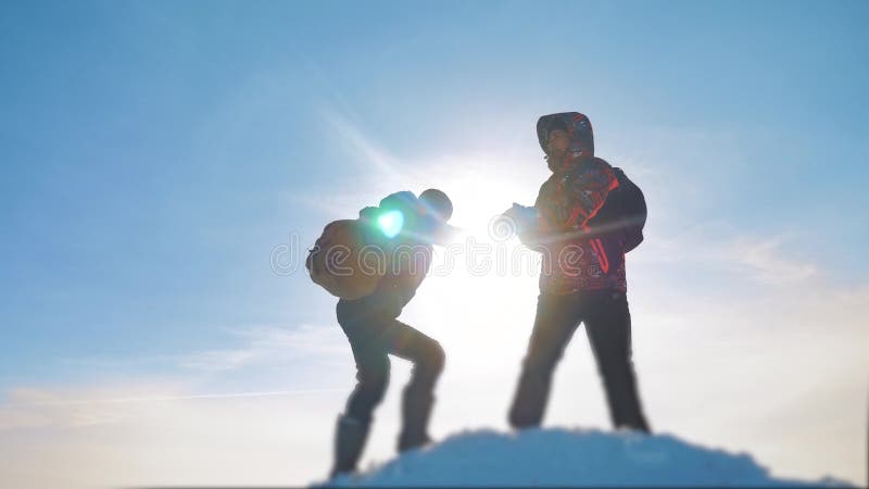 teamwork touristische Wanderer des Gruppenteams gibt eine Handreichung Erfolgsgewinnwinter erreichte die Spitze des Berges touris