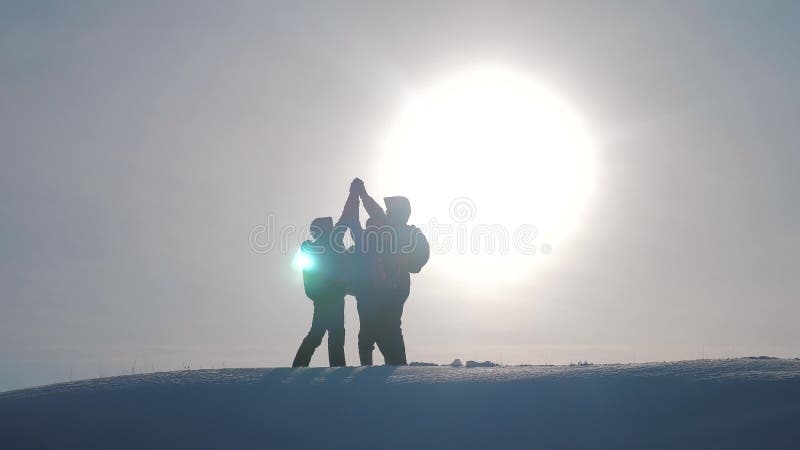 teamwork Wanderererfolgs-Gewinnwinter des Gruppenteams erreichte touristischer die Spitze des Gebirgsschattenbildsonnenlichts tou