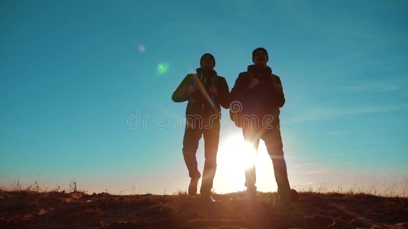 teamwork zwei Touristenwanderermänner und -hund mit Rucksäcken gehend bei Sonnenuntergang Reise, zu wandern gehen Zeitlupevideo r