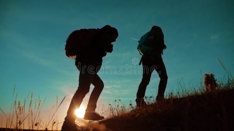 teamwork Zwei Wanderer, die den Sonnenaufgang geht von der Spitze eines Berges und des Hundes genießen Zeitlupevideo Zwei Wandere