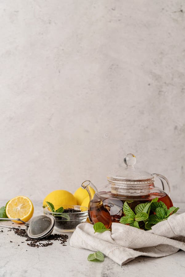 Teapot with Black Tea Decorated with Mint Leaves, Lemons and Dry Tea