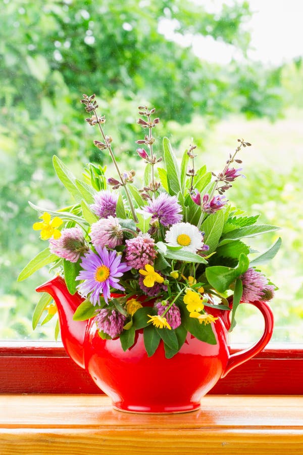 Teapot with bouquet of healing herbs and flowers